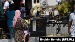 Žena drži dijete u ruci dok prosi novac na ulicama Prizrena na Kosovu