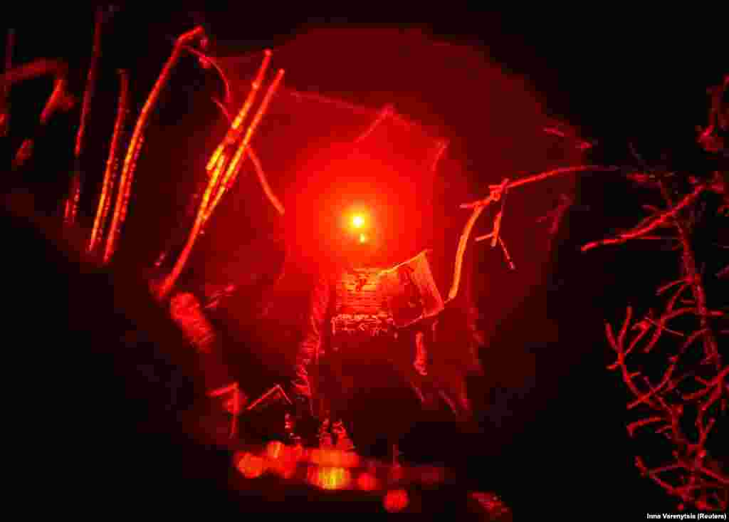 Використовуючи ліхтарик з червоним гелем для маскування своїх позицій, українські солдати керують безпілотником під покровом ночі. Дрони стали життєво важливим елементом у війні Києва проти московських військ, пропонуючи недорогу розвідку в режимі реального часу, а також можливість скидати вибухівку зі смертельними наслідками.