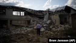  Oleksandr Piščik, direktor škole, stoji ispred školske biblioteke koja je uništena granatiranjem u Kupiansku, u Ukrajini, avgust 2023. 