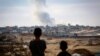 Dy djem duke e shikuar tymin që ngrihet lart nga ndërtesat në Rafah, Gazë, gjatë sulmeve izraelite kundër Hamasit, 31 maj 2024.