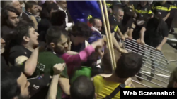 აქციის მონაწილეები ცდილობენ ჯებირის ნაწილის მორღვევას
