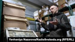 Сергій Звілінський показує одне з евакуйованих пано з родинними світлинами, яке було виявлено в одному з сіл поряд з Гуляйполем