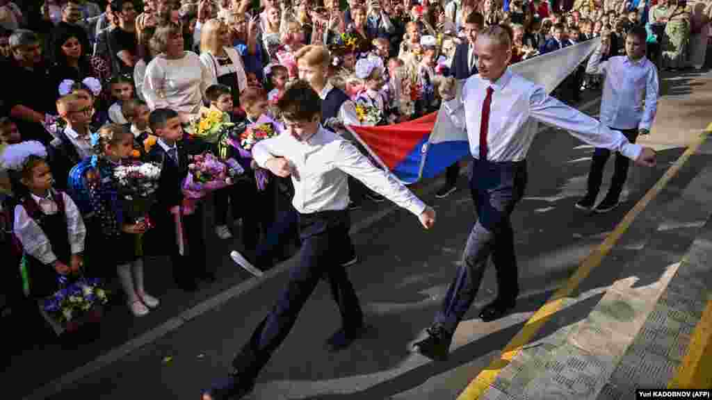 Orosz iskolás fiúk menetelnek egy moszkvai tanévkezdő ünnepségen szeptember 1-jén