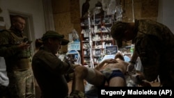 Військові медики лікують пораненого українського військового в польовому госпіталі поблизу Бахмута, Україна, середа, 12 липня 2023 року.