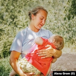 Жителька Мар'їнки годує дитину грудьми, літо 2018 року.