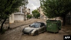 Снимка, показваща кола на кална улица след бурята "Елиас" във Волос