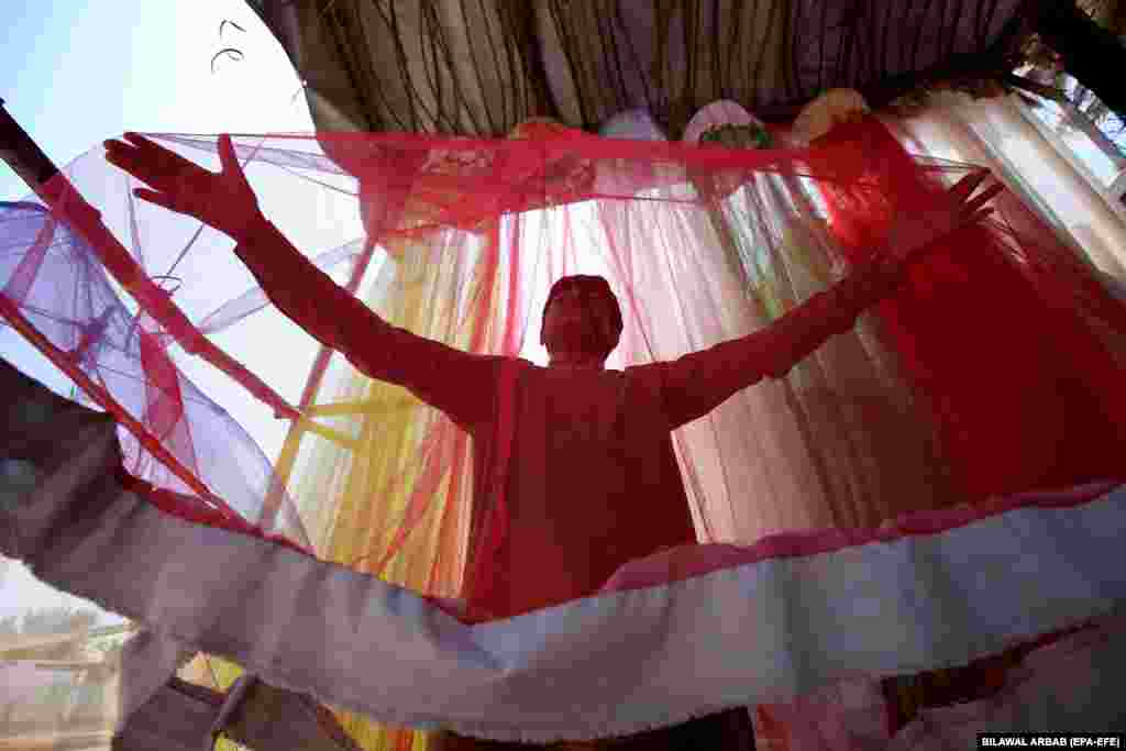 Peshawar, Pakistan, 25 aprilie: Un copil-negustor își așteaptă mușteriii: el vinde plase contra tânțarilor. Pe 25 aprilie a fost ziua internațională de luptă împotriva malaiei.