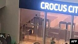 A terepruhás fegyveresek megközelítik az épületet