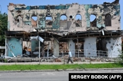 Чоловік проходить повз зруйновані будівлі в Ізюмі Харківської області, 27 липня 2023 року