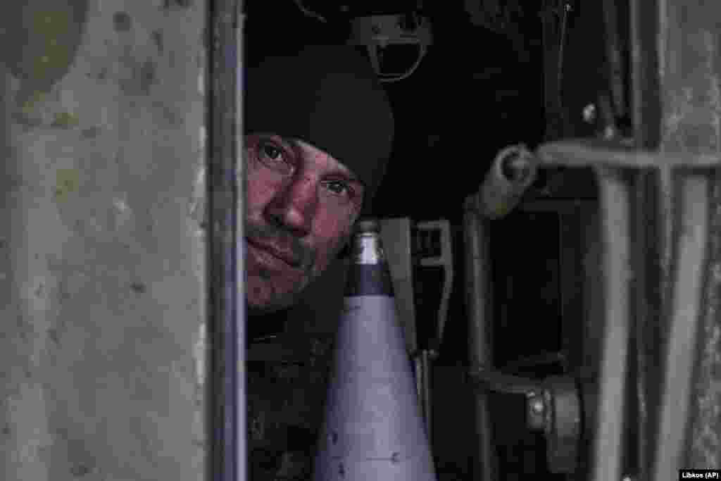 Un soldat ucrainean se uită prin trapa unui obuzier autopropulsat.