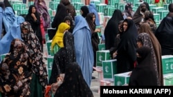 Ооган аялдары гуманитардык жардам алып жаткан учур. Герат, 21-июнь, 2023-жыл.