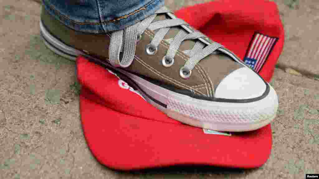 Egy Trump-ellenes várakozó az ikonikus&nbsp;Make America Great Again baseballsapkát tapossa New Yorkban 2024. május 30-án