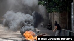 Un palestinian aruncă cu pietre în timpul unei operațiuni militare israeliene la Jenin, în Hebron, în Cisiordania ocupată de Israel, 4 iulie 2023