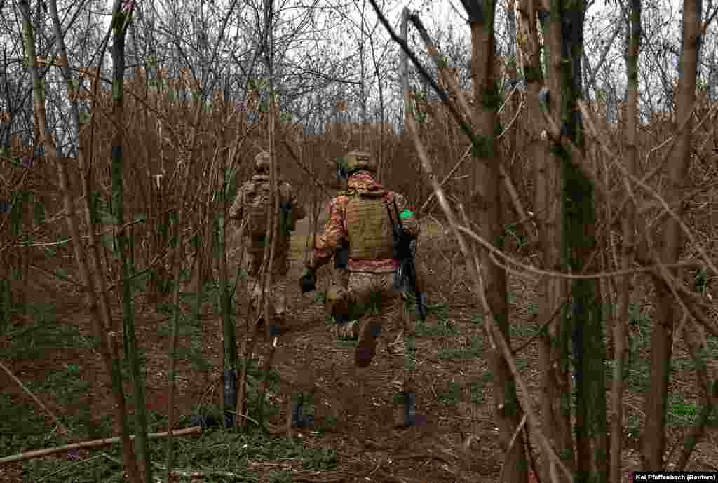 Soldați ucraineni din Brigada 28 Mecanizată aleargă spre pozițiile de pe linia frontului. În ciuda faptului că forțele ucrainene sunt depășite numeric, președintele Volodimir Zelenski a declarat că trupele sale vor continua să lupte pentru Bahmut, în ciuda situației &bdquo;foarte, foarte dificile&rdquo; de acolo.