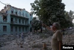 Një banor vendës duke qëndruar para një ndërtese të dëmtuar nga një sulm rus me raketë në Odesë, më 23 korrik 2023.