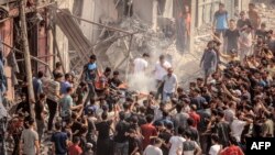 Газа тилкесинде жашагандар талкаланган үйлөрдүн арасынан жарадарларды жана курман болгондорду алып чыгып жатышат. 