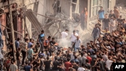 Palestinieni examinând urmările loviturilor aeriene israeliene asupra Fâșiei Gaza, luni, 9 octombrie.