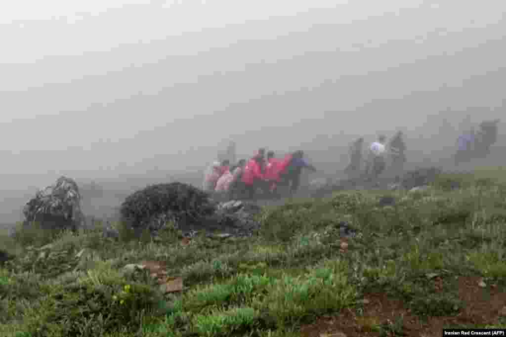 На скріншоті з відео, опублікованого Червоним Півмісяцем Ірану 20 травня, видно, як рятувальники витягують тіла на місці, де розбився гелікоптер із президентом Ірану Раїсі в оповитій туманом гірській місцевості на північному заході Ірану. 63-річного Раїсі та його супутників, враховуючи міністра закордонних справ Хосейна Аміра-Абдоллахяна, знайшли мертвими на місці катастрофи