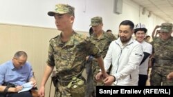 Азамат Ишенбеков менен Актилек Капаров Ленин райондук сотуна алынып келаткан учур. 7-июнь, 2024-жыл.