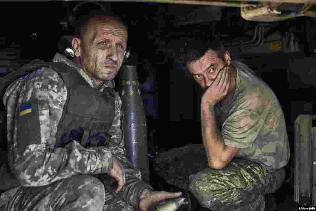 Ukrainian soldiers wait inside a self-propelled howitzer.