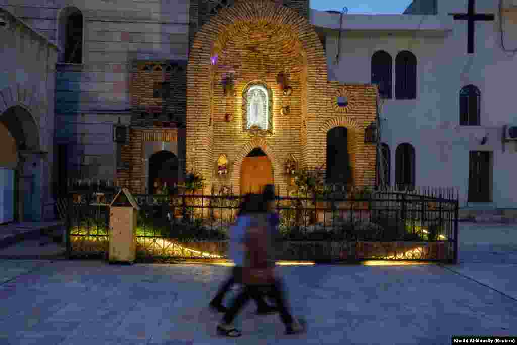 Disa qytetarë duke kaluar pranë një Kishe në Al-Hamdania të Irakut më 8 prill, në vigjilje të Pashkëve.