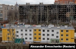 Нові будинки в Маріуполі на фоні вигорівших від обстрілів, лютий 2023 року