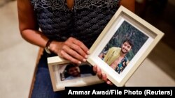 Rachel Goldberg, majka Hersha Goldberga Polina, kojeg su Hamasovi militanti uzeli kao taoca u Pojas Gaze dok je bio na muzičkom festivalu u južnom Izraelu, drži fotografije svog sina u njihovoj kući, u Jerusalimu, 17. oktobra 2023. 