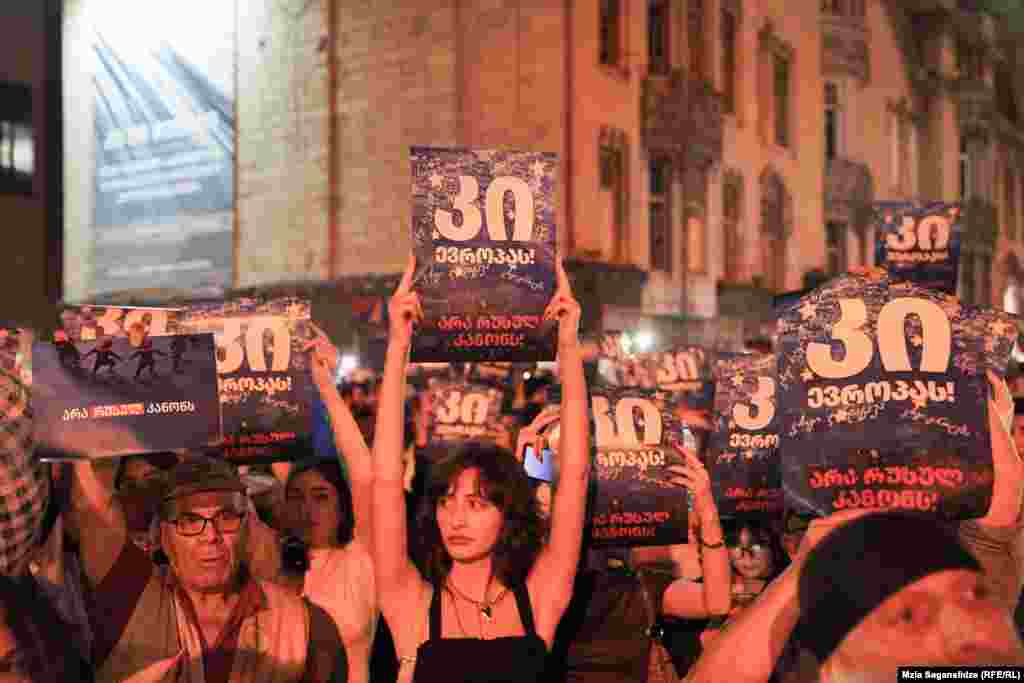 Протестувальники тримають плакати з написом: &laquo;Так Європі&raquo; та &laquo;Ні російському закону&raquo;