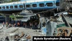 Romeltakarítás egy orosz légicsapás után az ukrajnai Dnyipróban 2023. augusztus 24-én