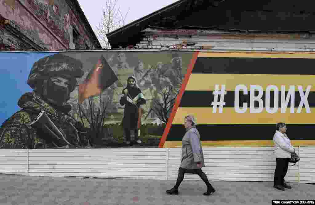 Žena prolazi pored transparenta koji prikazuje ruskog vojnika u Jefremovu, Tulska oblast, Rusija.
