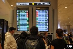 Putnici gledaju u tablu za polazak na aerodromu Ben Gurion u blizini Tel Aviva, Izrael, 7. oktobra, dok su letovi otkazani zbog iznenadnih napada Hamasa.