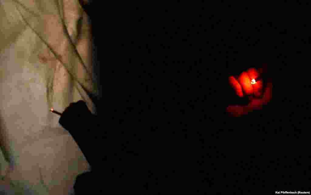 Militarii ucraineni din Brigada Mecanizată 28 trag o țigară în timp ce se adăpostesc în tranșee de proiectilele lansate de artileria rusă, 5 aprilie 2023