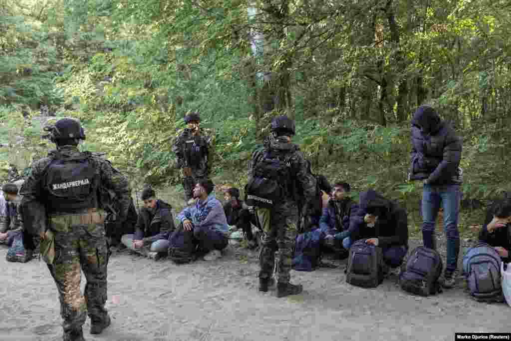 Migrante koji su uhvaćeni u blizini srpsko-mađarske granice čuvaju srpski specijalci u blizini grada Subotice 12. septembra. Srbija se nalazi na glavnoj ruti za migrante iz Azije, Afrike i Bliskog istoka koji žele da stignu do EU. Srpska policija je dugo bila na granici, ali je sada tu oblast pojačala teže naoružanim osobljem.