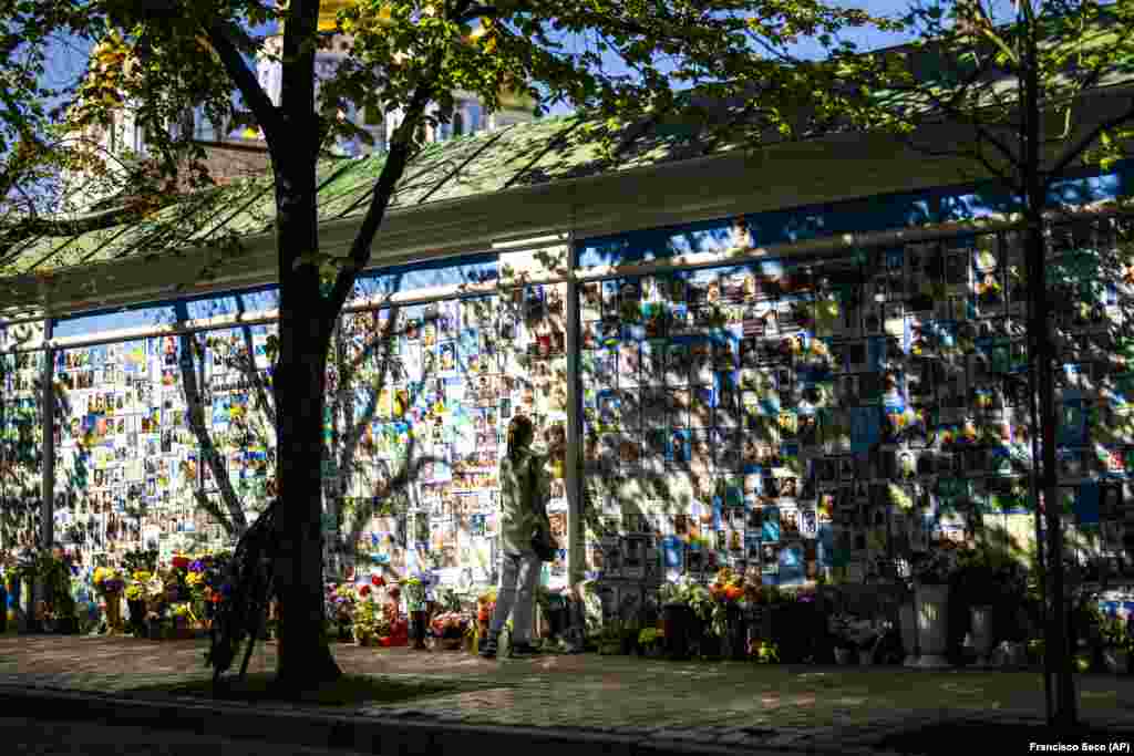 O femeie atinge o fotografie a unui soldat ucrainean la un zid comemorativ pentru cei căzuți în timpul războiului cu forțele rusești invadatoare, la Catedrala Sfântul Mihail din Kiev.&nbsp; &nbsp;