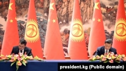 Кыргызстандын президенти Садыр Жапаров менен Кытайдын лидери Си Цзинпин документтерге кол коюу учурунда. 