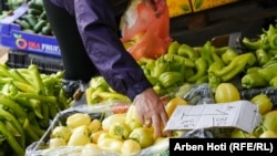 Një grua duke blerë speca në treg në Prishtinë. Fotografi nga arkivi.
