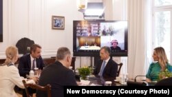 Takimi i kryeministrit grek me deputetët e zgjedhur për Parlamentin Evropian nga partia e tij, Demokracia e Re - në mesin e tyre shihet edhe Alfred Beleri (djathtas në ekran) nëpërmjet videolidhjes.