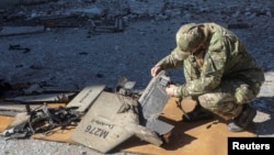 Ілюстраційне фото. Офіцер поліції оглядає уламки ударного дрона з маркуванням «Герань-2» у Харкові, жовтень 2022 року