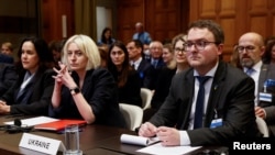 Представителите на Украйна Оксана Золотарьова и Антон Кориневич гледат как Международният съд (МС) на ООН се произнася по искането на Русия да отхвърли делото за геноцид в Украйна, 2 февруари 2024 г.