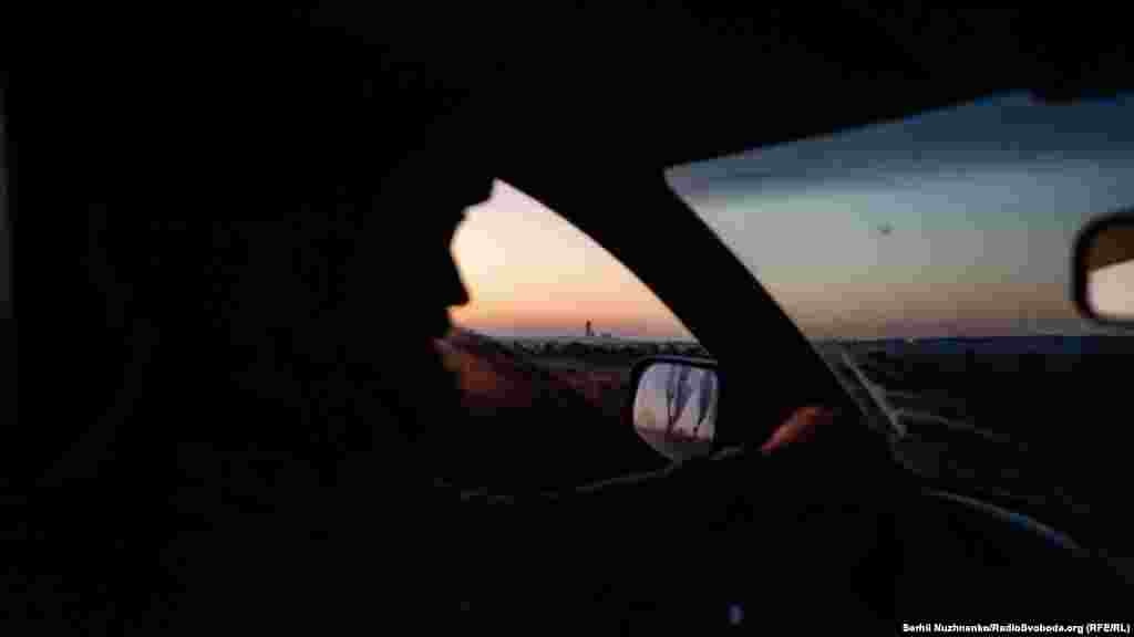 A Vuhledar szénbánya tornyai az ostromlott városba vezető út mellett. A vezetés napfelkelte előtt csökkenti annak kockázatát, hogy orosz kamikazedrónok célba vegyék az úton lévőket. Bombákat ledobó kvadkoptereket is használnak ezeken a keleti utakon, hogy katonai felszereléseket és néha még civil autókat is célba vegyenek