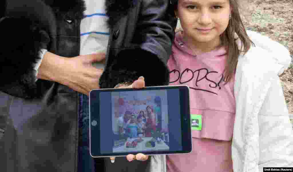 Serap Bas, 38 vjeçe, tregon një foto me burrin e saj Omer Bas, 43 vjeç, dhe fëmijët e saj Nil Cemre Bas dhe Ekrem Bugra Bas, të cilët vdiqën të gjithë gjatë tërmetit të vitit të kaluar. Serap&nbsp; dhe vajza e saj 8 vjeçe, Ecrin Gokce Bas, u fotografuan në zonën pastruar ku dikur ndodhej shtëpia e tyre, në Hataj, Turqi, shkurt 2024.