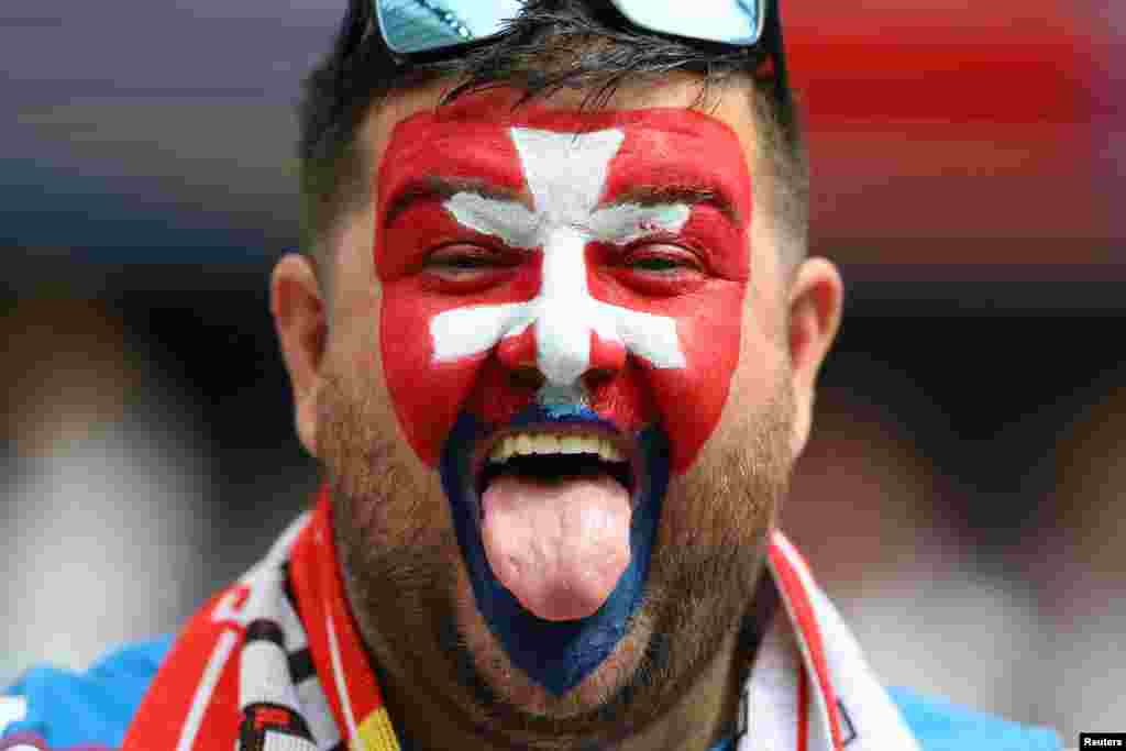 Словацкий болельщик с раскрашенным в цвета флага своей страны лицом ждёт начала матча группы E. Бельгия встречается со Словакией во Франкфурте, 17 июня. Сборная Бельгии уступила Словакии со&nbsp;счётом 0:1. Два гола бельгийцев не были засчитаны
