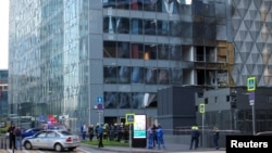 Echipajele de urgență în fața unei clădiri de birouri avariate din Moscova, în urma unui atac de dronă din 30 iulie.