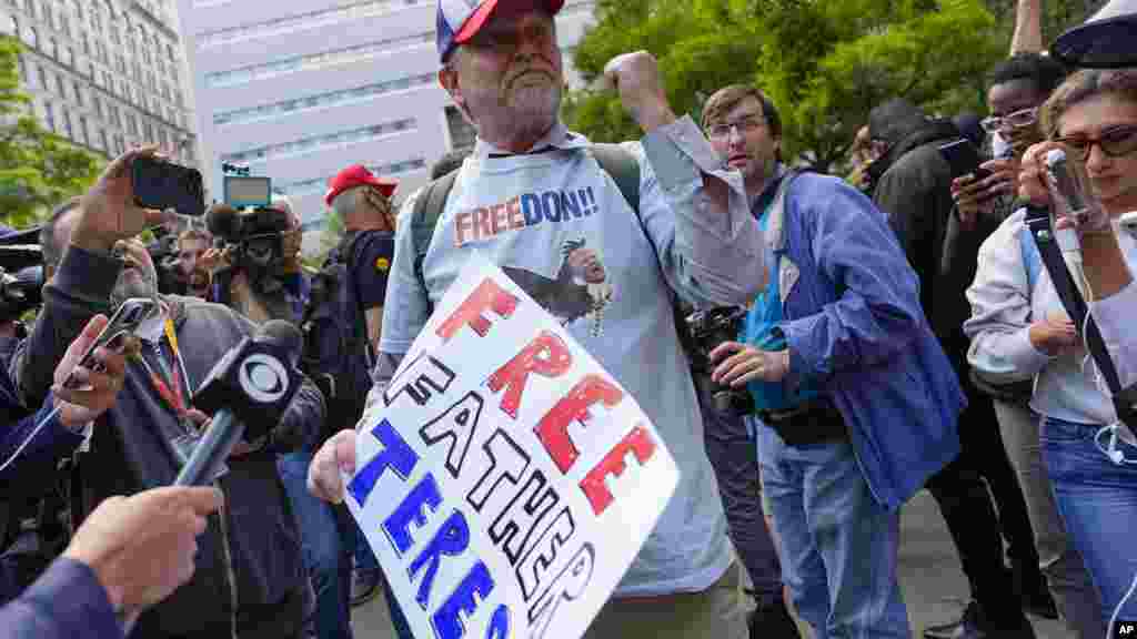 Trump egyik támogatója az ítélethirdetés után,&nbsp;május 30-án&nbsp;New Yorkban. A hamisítással a Stormy Daniels pornósztár hallgatásáért fizetett pénz eltitkolása volt a cél. A vád szerint Trump ügyvédje, Michael Cohen révén százharmincezer dollárt fizetett Danielsnek a nyolc évvel ezelőtti elnökválasztási kampány napjaiban, hogy ne teregesse ki korábbi viszonyukat