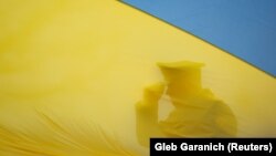 Украинанын желегинин артында турган аскер адамы. Иллюстрация.