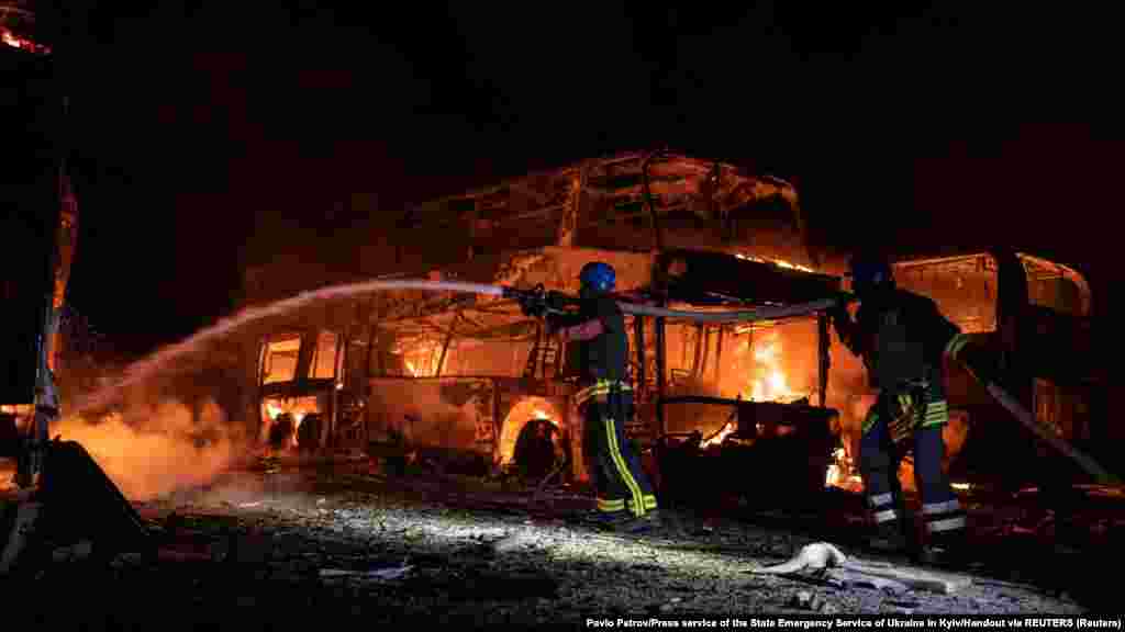 Tűzoltók dolgoznak a lehulló törmeléktől kigyulladt parkolóban. Kijevben egy nagyobb épület is kiégett.&nbsp;A fővárost érő kedd hajnali támadás a nyolcadik volt ebben a hónapban