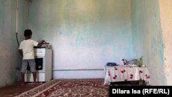 Әлеуметтік жағдайы төмен отбасындағы бала түскі асын ішу үшін отқа шай қойып жатыр. Шымкент, 2 тамыз, 2023 жыл (Азаттық архивіндегі фото)