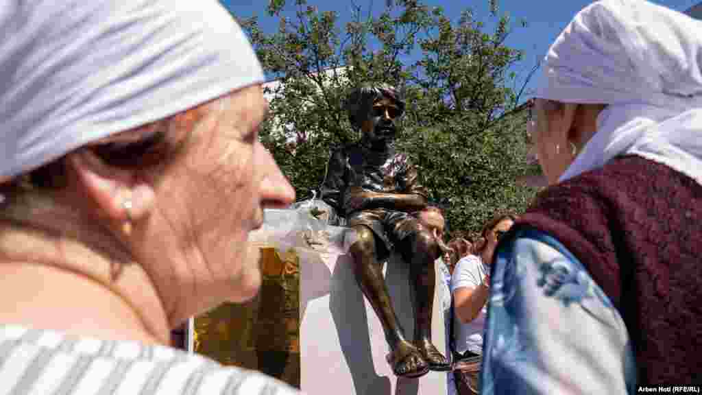 Nëna e Leotrim Ahmetit në përurimin e shtatores së tij. Shtatëvjeçari u vra gjatë luftës në Kosovë. Figura e 7-vjeçarit me dorën në bark, është punuar bazuar në rrëfimin e së ëmës. Leotrimi, pasi është plagosur, i kishte thënë nënës së tij se ka diçka në bark, që është &ldquo;i sëmurë nga barku&rdquo;. Pas disa orëve, ai kishte vdekur.