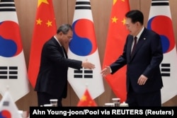 Predsjednik Južne Koreje (desno) se rukuje sa kineskim premijerom Lijem Kuangom, 26. maj 2024.