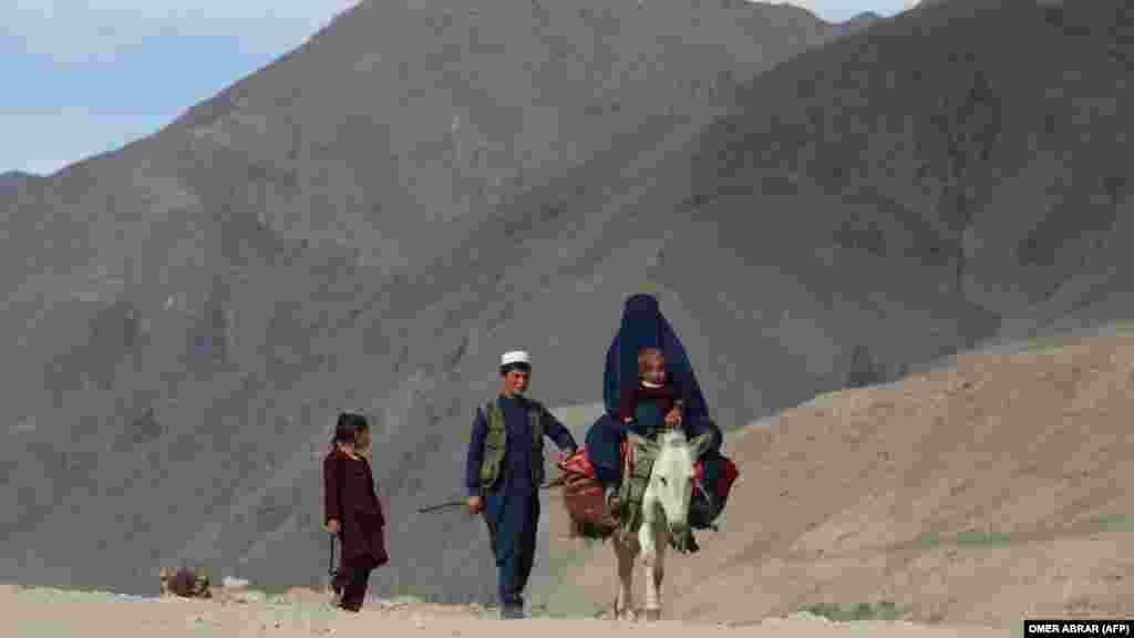 Žena obučena u burku i dijete jašu magarca dok dvoje djece šetaju putem u afganistanskoj provinciji Badakhshan.